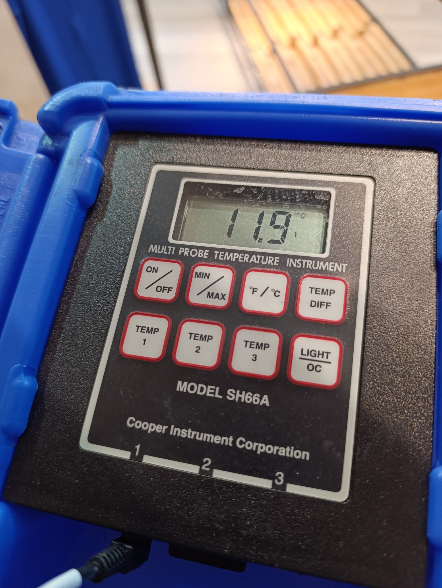 Cyfrowy termometr wielopróbkowy, model SH66A, wskazujący temperaturę 11.9 stopni Celsjusza, umieszczony w niebieskiej obudowie.