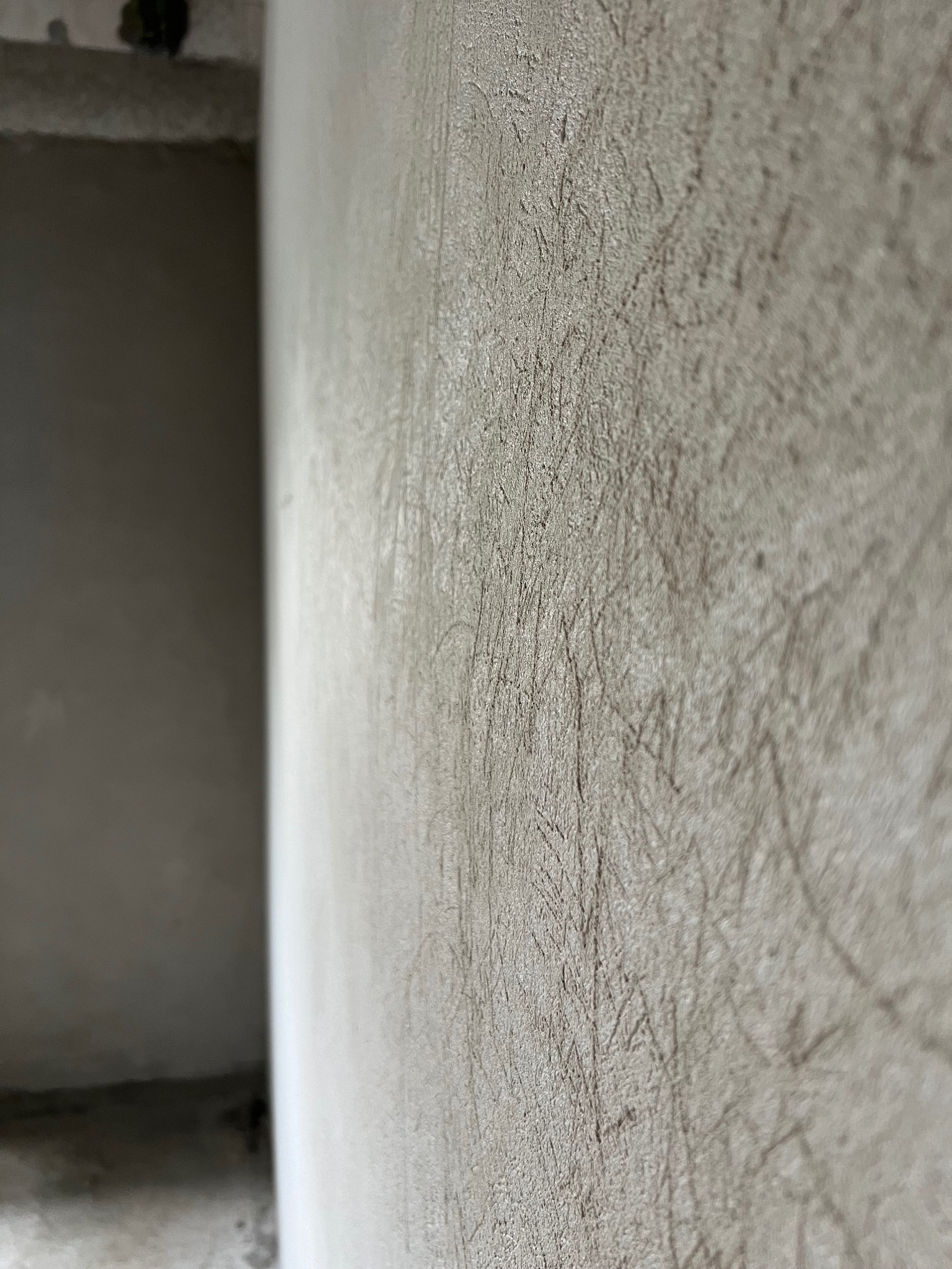 Ściana po szpachlowaniu, widoczne ślady po narzędziach, przygotowana do dalszych prac wykończeniowych.