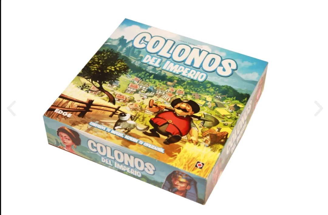 Pudełko gry planszowej 'Colonos del Imperio' z ilustracją osadnika z łopatą, psa i wioski w tle.