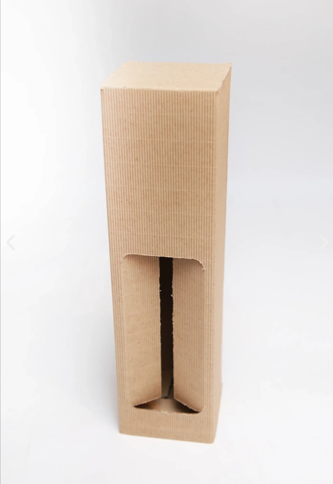 Wysokie, wąskie pudełko z brązowej tektury falistej z wyciętym otworem inspekcyjnym, widok z przodu na białym tle.