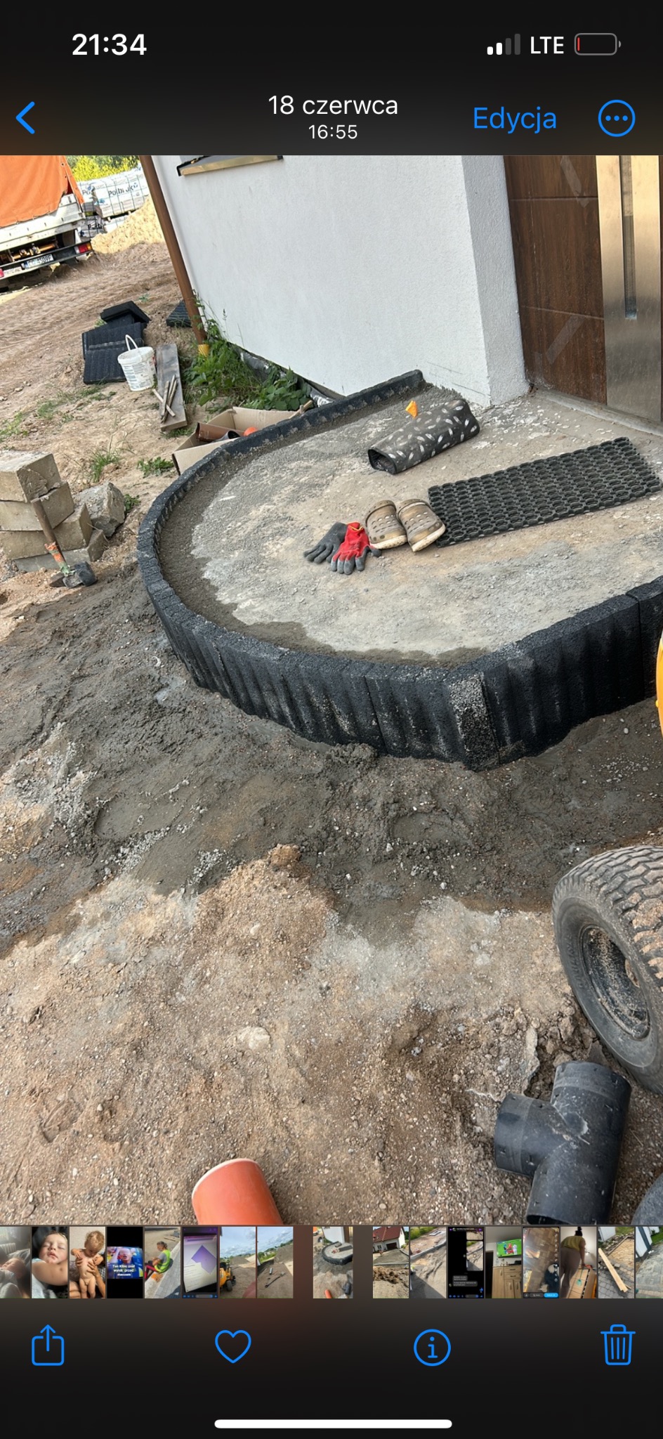 Przygotowanie okrągłego podłoża z obrzeżem z tworzywa, widoczne rękawice robocze, crocsy i wycieraczki, w tle budynek i samochód dostawczy.