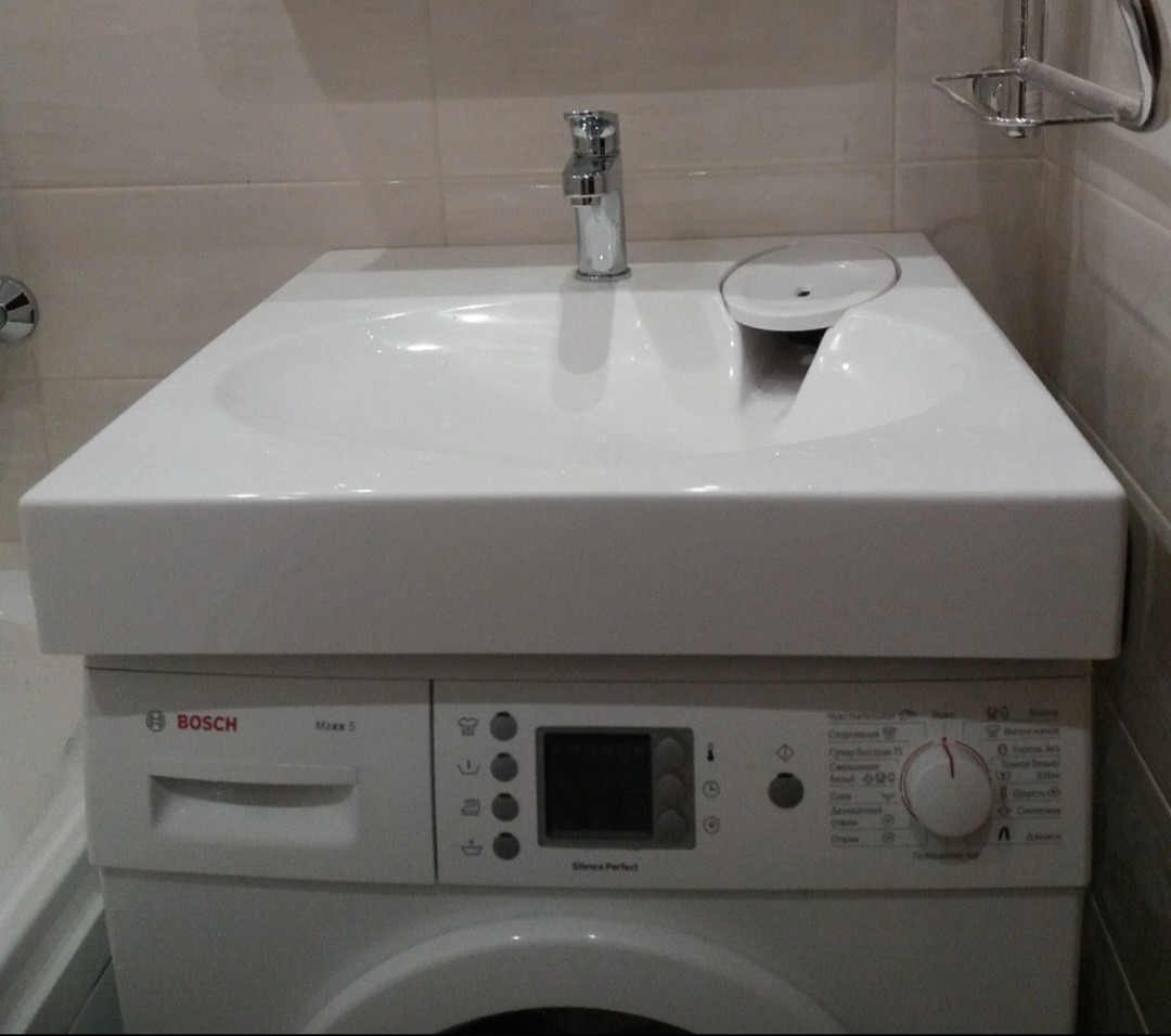 Biała umywalka nablatowa z chromowaną baterią zamontowana bezpośrednio na pralce Bosch Maxx 5 w łazience z jasnymi płytkami.