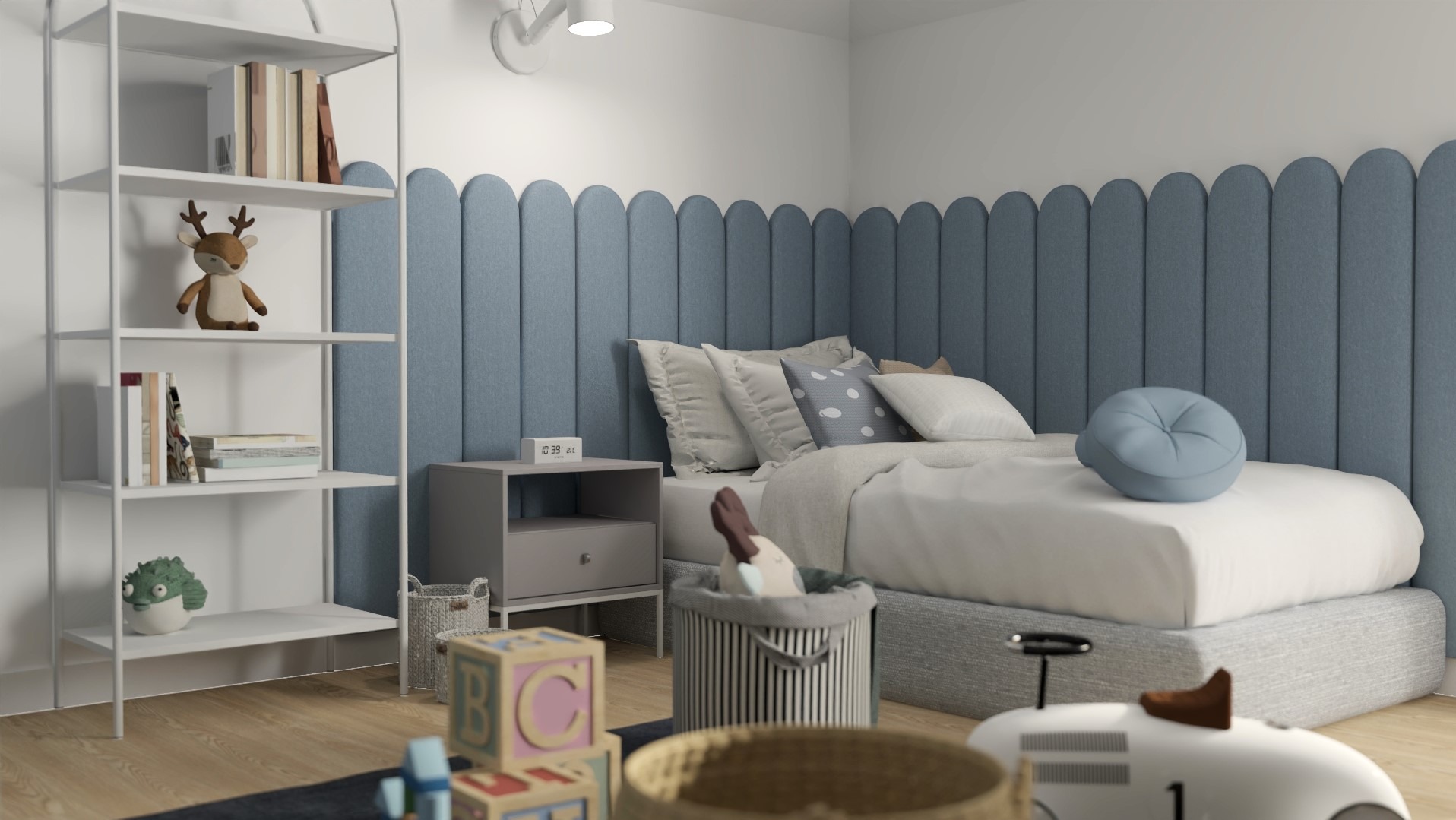 Pokój dziecięcy z łóżkiem z niebieskim zagłówkiem w kształcie zaokrąglonych paneli, białym regałem z książkami i zabawkami oraz stolikiem nocnym z elektronicznym zegarem.