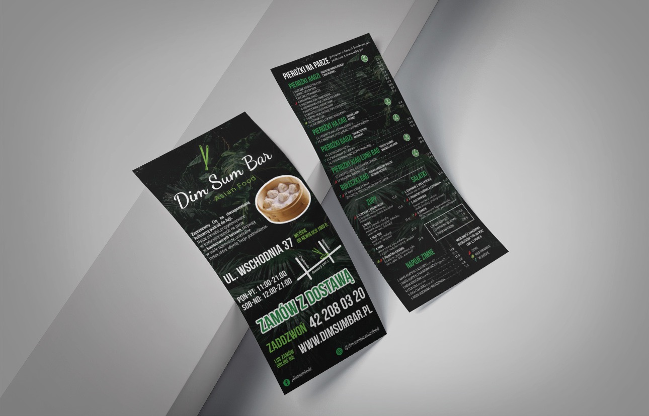 Dwa czarno-zielone foldery reklamowe restauracji Dim Sum Bar z menu i informacjami kontaktowymi leżące na jasnoszarym tle.