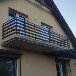 sPaweł Paweł Kurpierz - Nowoczesna balustrada balkonowa z poziomych, ciemnych profili, widoczna na tle elewacji domu oraz częściowo zadaszona pergola metalowa