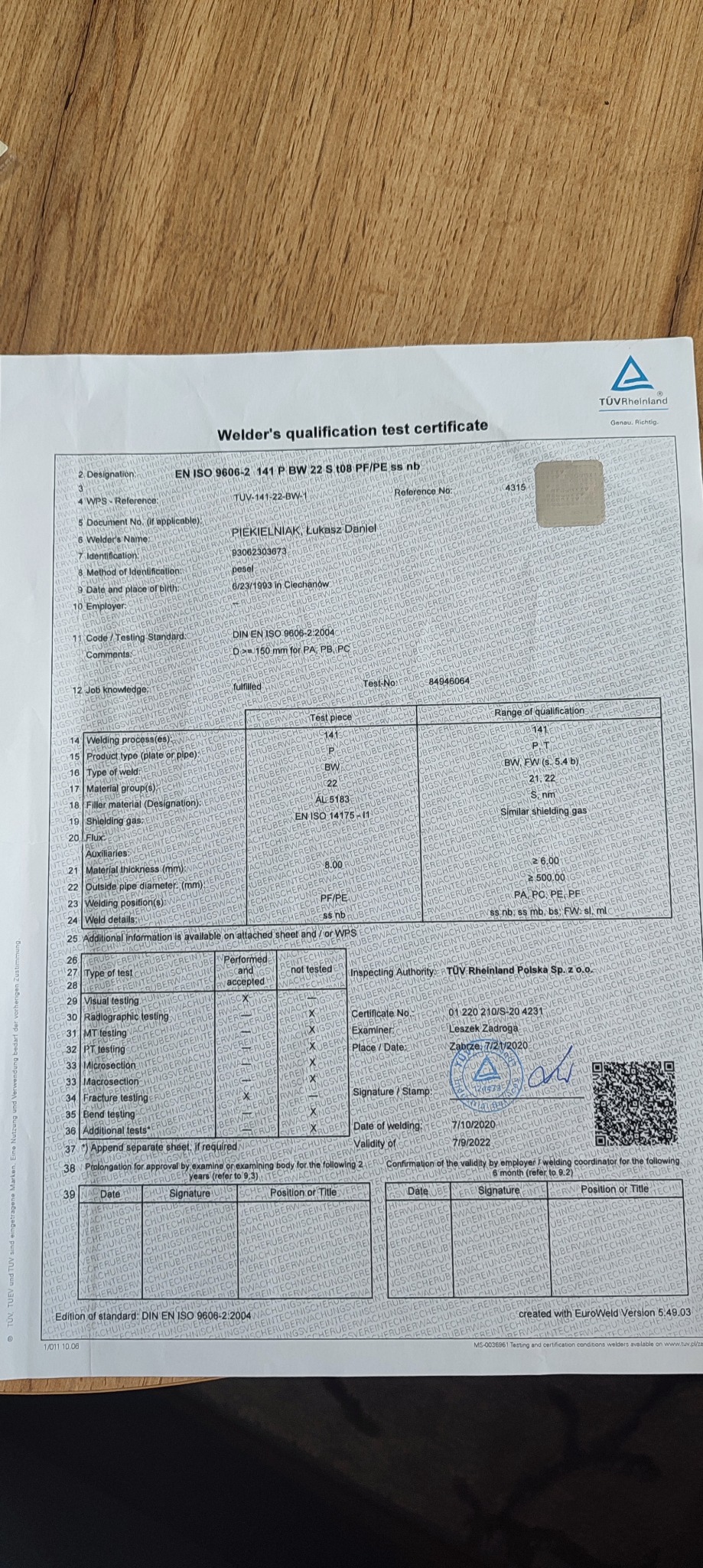 Skan certyfikatu kwalifikacji spawacza, zawierający dane osobowe, informacje o normie DIN EN ISO 9606-2:2004, zakres kwalifikacji, datę spawania, pieczątki i podpisy.