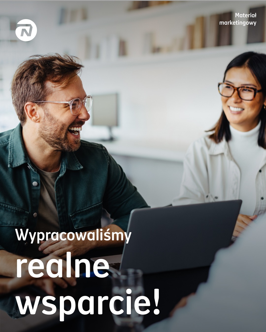 Uśmiechnięci konsultanci przy laptopie, z tekstem 'Wypracowaliśmy realne wsparcie!', w jasnym biurze. Materiał marketingowy z logo firmy w lewym górnym rogu.