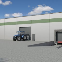 Piotr Jasiczak - Nowoczesna hala magazynowa z szarymi panelami i zielonym pasem, z rampą załadunkową, zaparkowanym niebieskim traktorem i postacią w garniturze przy drzwiach wejściowych.