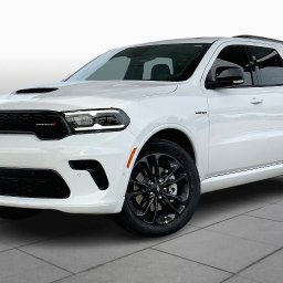 MIKAR MIKOŁAJ KARPIŃSKI - Biały samochód Dodge Durango z czarnymi felgami, widok z przodu i boku, na jasnym tle z płytek.