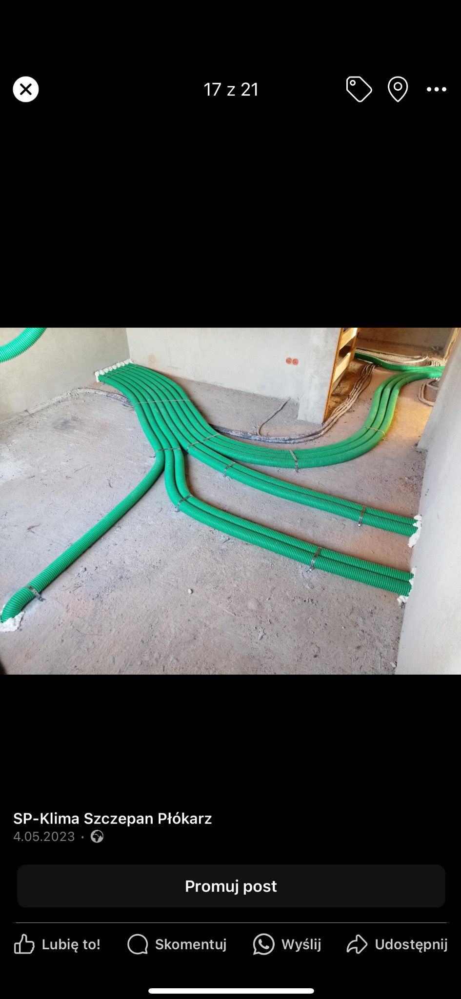 Zielone rury wentylacyjne ułożone na surowej podłodze w trakcie instalacji, z widocznymi mocowaniami i pianką uszczelniającą przy ścianie.