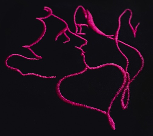 Czarna tkanina z abstrakcyjnym, różowym haftem przedstawiającym profil twarzy kobiety i serce.