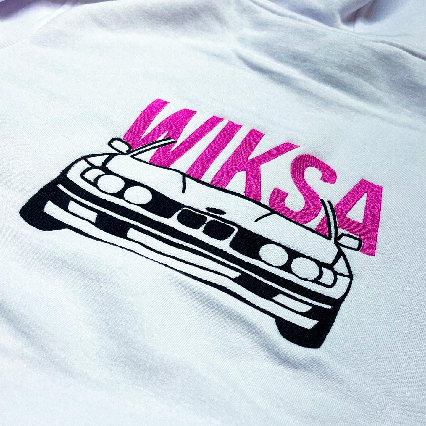 Biała koszulka z haftowanym czarno-białym samochodem i różowym napisem 'WIKSA'.