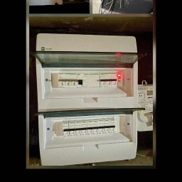 Rafał Świderski - Rozdzielnica elektryczna dwusegmentowa, biała, z otwartą górną częścią, widoczne zabezpieczenia. U góry kolaż zdjęć stanu przed modernizacją.