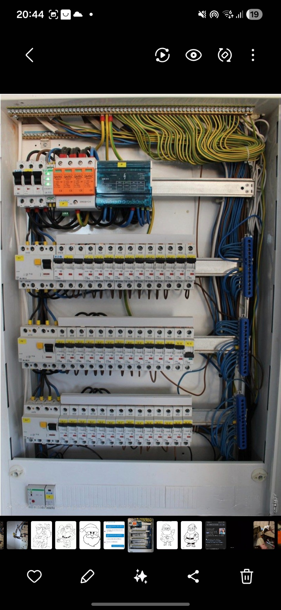 Rozdzielnica elektryczna z zabezpieczeniami, przewodami i listwami zaciskowymi. Widoczne bezpieczniki, ograniczniki przepięć i starannie ułożone kable wewnątrz obudowy.