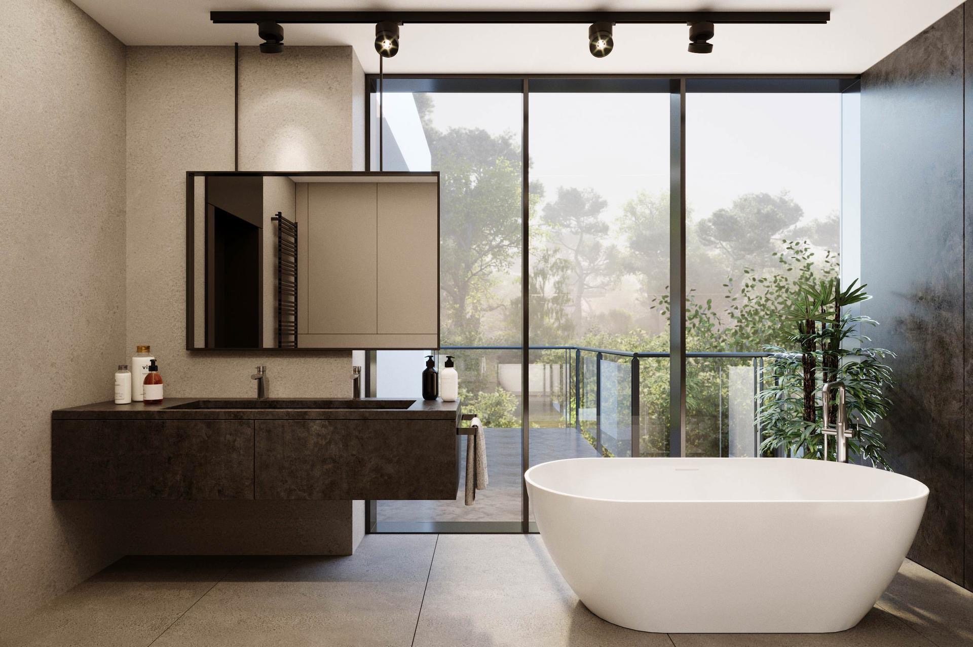 Nowoczesna łazienka z dużym oknem, widok na zieleń, minimalistyczna umywalka z ciemnego kamienia, wolnostojąca biała wanna, oświetlenie punktowe na suficie.