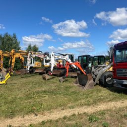 Świętokrzyskie Prace Ziemne Karol Kot - Sprzęt budowlany: żółta ubijarka gruntu, żółta niwelatorka na statywie, koparki Liebherr, Takeuchi, Bobcat i Kubota oraz ładowarka Volvo i czerwona ciężarówka MAN, ustawione na trawiastym terenie...
