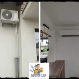 Zewnętrzna i wewnętrzna jednostka klimatyzacji AUX zamontowana na ścianie budynku jednorodzinnego, widoczne rury odprowadzające skropliny. W tle okno z kwiatami.