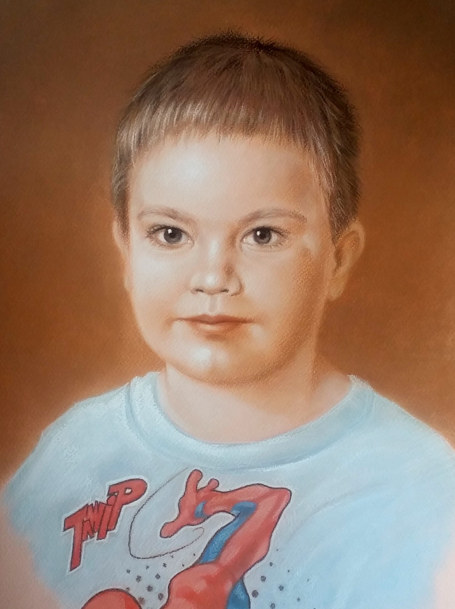 Portret chłopca w pastelach, ubrany w koszulkę z motywem Spider-Mana, na jednolitym, brązowym tle.
