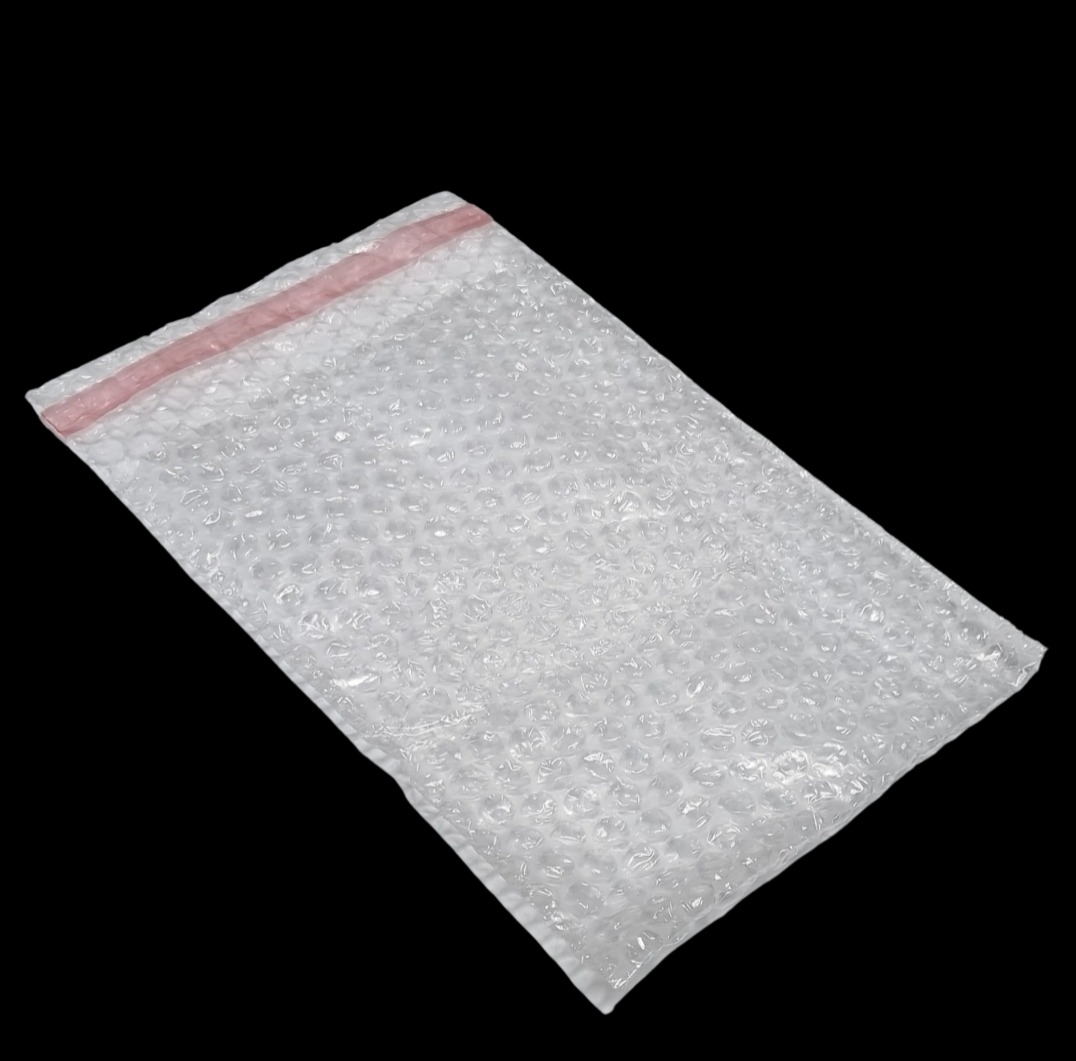 Płaska, przezroczysta koperta z folii bąbelkowej z różowym paskiem zamykającym, na czarnym tle.