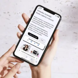 Kobieta trzyma iPhone z wyświetloną stroną internetową wirtualnej asystentki, prezentującą ofertę wsparcia biznesu.