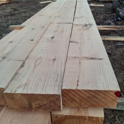 Tartak Andrzej Niesterczuk - Stos świeżo przetartego drewna sosnowego ułożony na zewnątrz, widoczne słoje i naturalne przebarwienia.