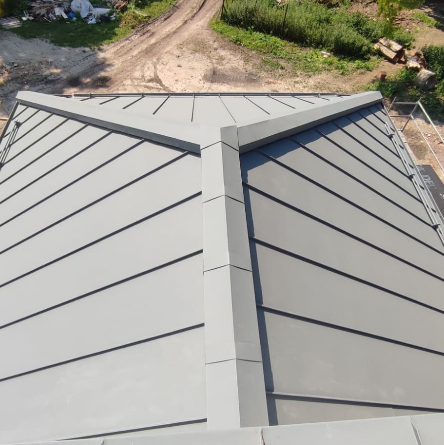 Widok z góry na nowo pokryty, grafitowy dach z blachy na rąbek stojący w Lublinie, z widocznymi liniami łączeń i elementami obróbki blacharskiej.