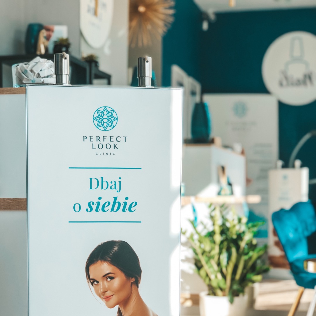 Reklama kliniki 'Perfect Look Clinic' z hasłem 'Dbaj o siebie' i wizerunkiem kobiety, widoczna w jasnym wnętrzu z rośliną doniczkową i elementami dekoracyjnymi w odcieniach błękitu.