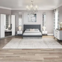 Elegancka sypialnia w odcieniach szarości i bieli z dużym ł&oacute;żkiem, szafkami nocnymi, lustrami dekoracyjnymi i drewnianą podłogą, oświetlona ozdobnym żyrandolem.