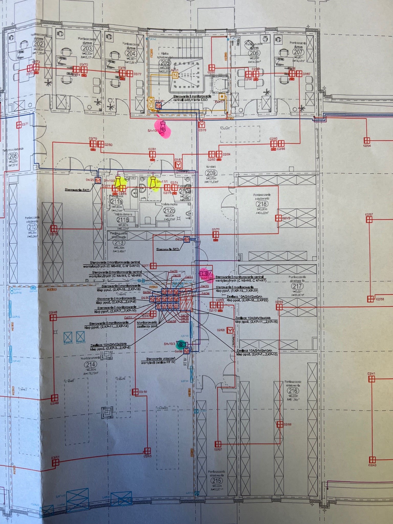 Plan architektoniczny budynku z zaznaczonymi instalacjami elektrycznymi i systemami sterowania, widoczne oznaczenia pomieszczeń i elementy wyposażenia.