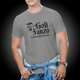 Blank Sp. z o.o. - Mężczyzna w szarej koszulce z czarnym nadrukiem 'Goli Fanzo BARBER FRYZJER' i grafiką brodatego mężczyzny, jeansowa koszula zawiązana w pasie, na nadgarstku brązowy zegarek.