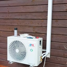 MCSerwisPlus - Montaż klimatyzacji Cooper&Hunter na drewnianej elewacji w Szczecinie. Widoczne narzędzia i puszka farby na klimatyzatorze. Instalacja w trakcie podłączania.