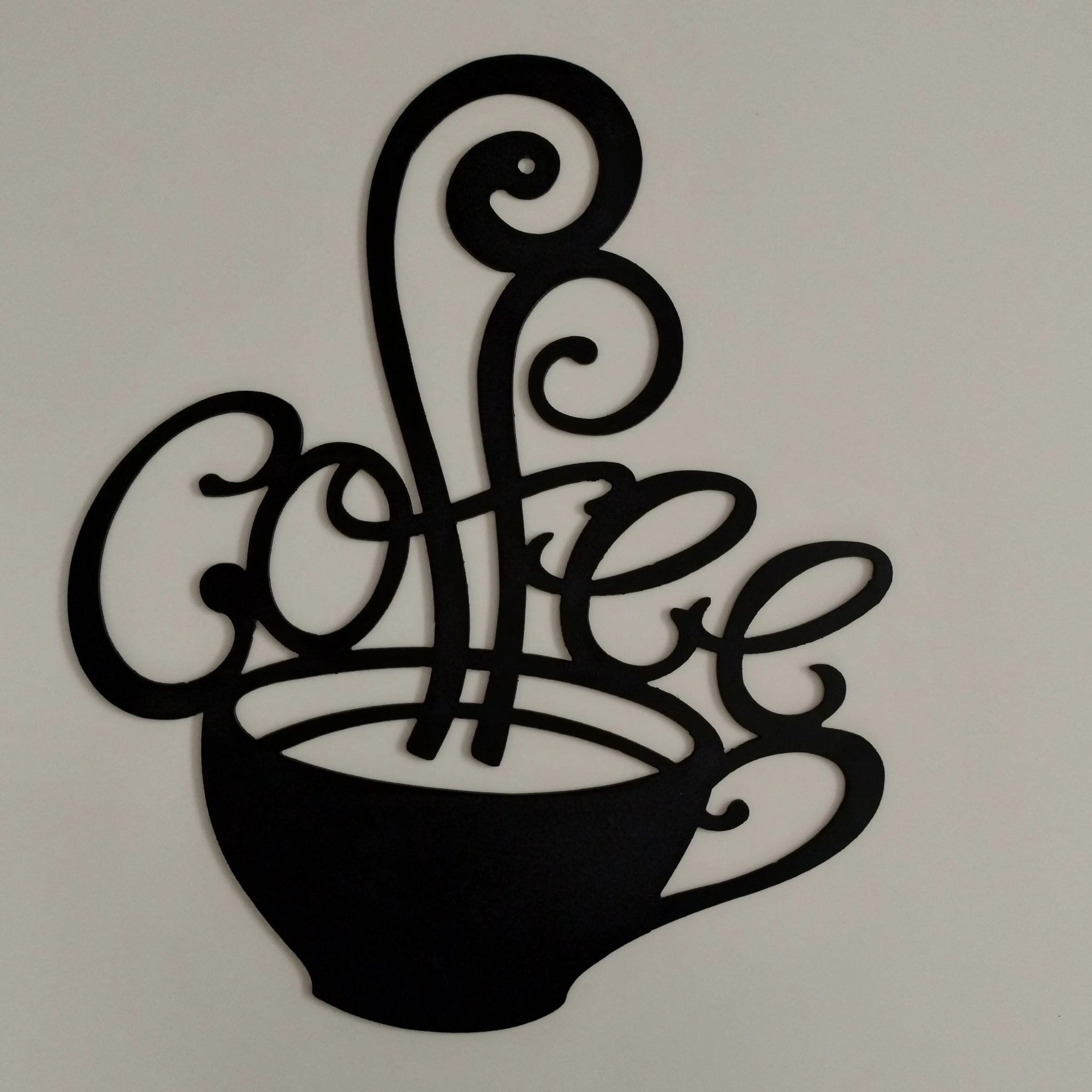 Czarna, metalowa dekoracja ścienna przedstawiająca filiżankę kawy z napisem 'coffee', wykonana techniką cięcia CNC.