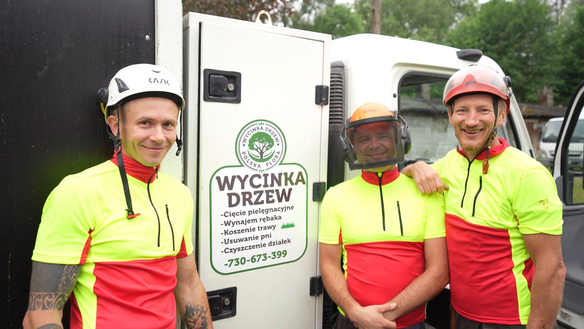 Trzech uśmiechniętych mężczyzn w odzieży roboczej stoi przed samochodem z logo firmy zajmującej się wycinką drzew, widoczny numer telefonu i zakres usług.