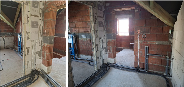 Surowy stan poddasza z widocznymi przewodami elektrycznymi ułożonymi wzdłuż ścian z pustaków, instalacja sanitarna w tle, widoczne puszki instalacyjne i przewody wychodzące ze ściany.