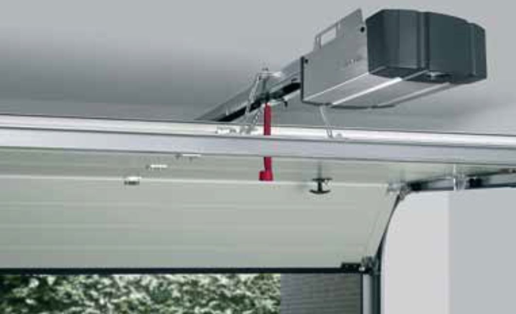 Zamontowany napęd elektryczny bramy garażowej w Magnuszewie, widoczne elementy mocujące i fragment bramy z perspektywy wnętrza garażu.