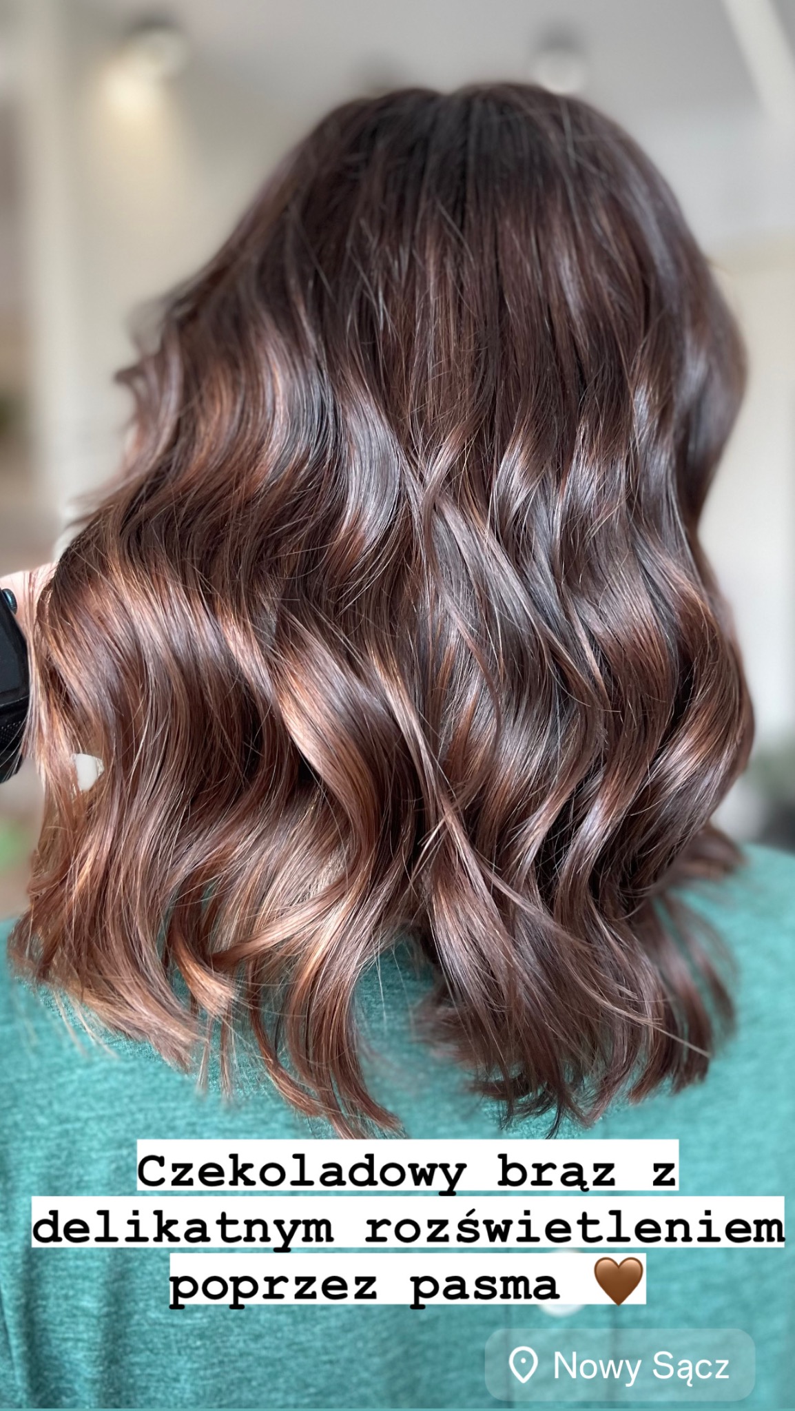 Czekoladowy brąz z delikatnym rozświetleniem poprzez pasma na falowanych włosach, widok z tyłu.