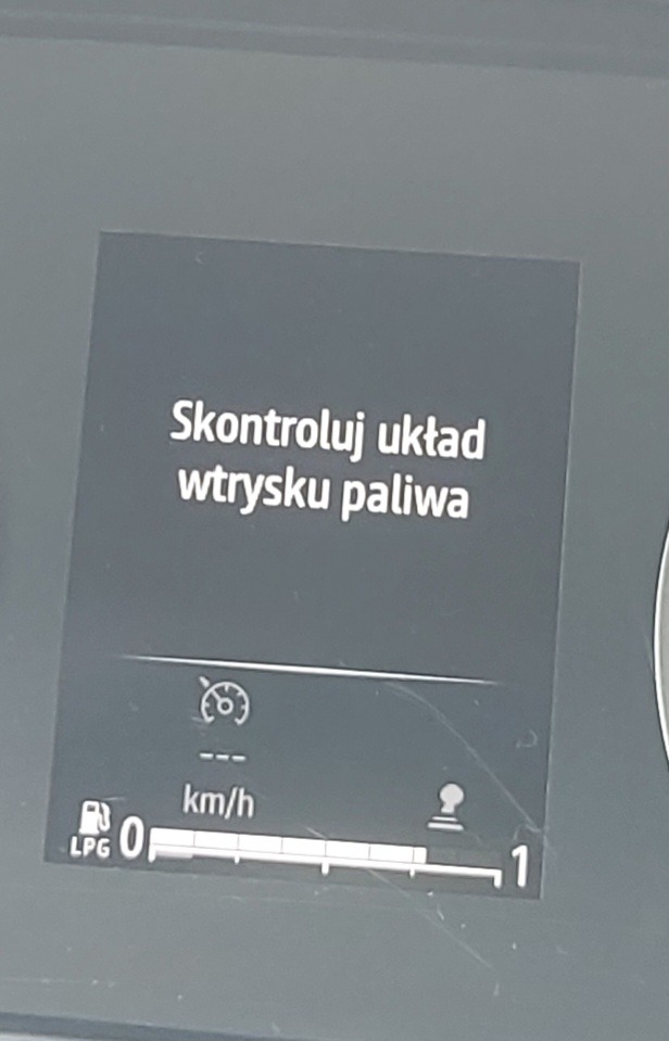 Wyświetlacz samochodowy z komunikatem 'Skontroluj układ wtrysku paliwa' oraz ikoną LPG i wskazaniem 0 km/h.