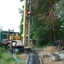 P.W.Eko-Live J.Krzysztofczyk - Wiertnica zamontowana na ciężarówce, przygotowana do wiercenia studni głębinowej na zalesionej działce, widoczne węże i elementy instalacji.