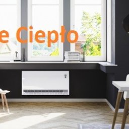 P.W.Eko-Live J.Krzysztofczyk - Eleganckie wnętrze z grzejnikiem elektrycznym pod oknem, szary fotel z czerwoną poduszką, biały stół z krzesłami, czarne lampy wiszące, parkiet na podłodze.