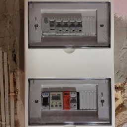 ELEKTROSERWIS Paweł Waligórski - Rozdzielnica elektryczna firmy Elektro-Plast z zainstalowanymi bezpiecznikami Eaton i modułem sterującym ENEXT 32A, zamontowana na surowej ścianie.