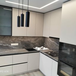 VS FURNITURE SPÓŁKA Z OGRANICZONĄ ODPOWIEDZIALNOŚCIĄ - Nowoczesna kuchnia w odcieniach szarości i bieli z marmurowym blatem, oświetleniem LED i czarnymi wiszącymi lampami cylindrycznymi.