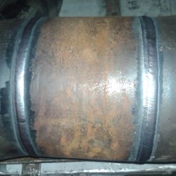 Instal-Met serwis - Spoina na rurze stalowej, widoczne ślady rdzy i niedoskonałości spoiny, surowy stan techniczny.