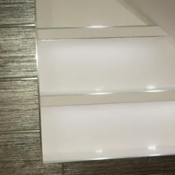 Nowoczesna łazienka w skosie z podświetlanymi półkami szklanymi i płytkami o fakturze drewna oraz przyciskiem spłuczki.