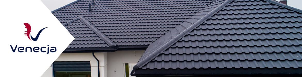 Szczegółowe ujęcie czarnego dachu z blachodachówki modułowej firmy Venecja, z widocznymi rynnami i elementami wykończeniowymi, na tle jasnej elewacji domu.