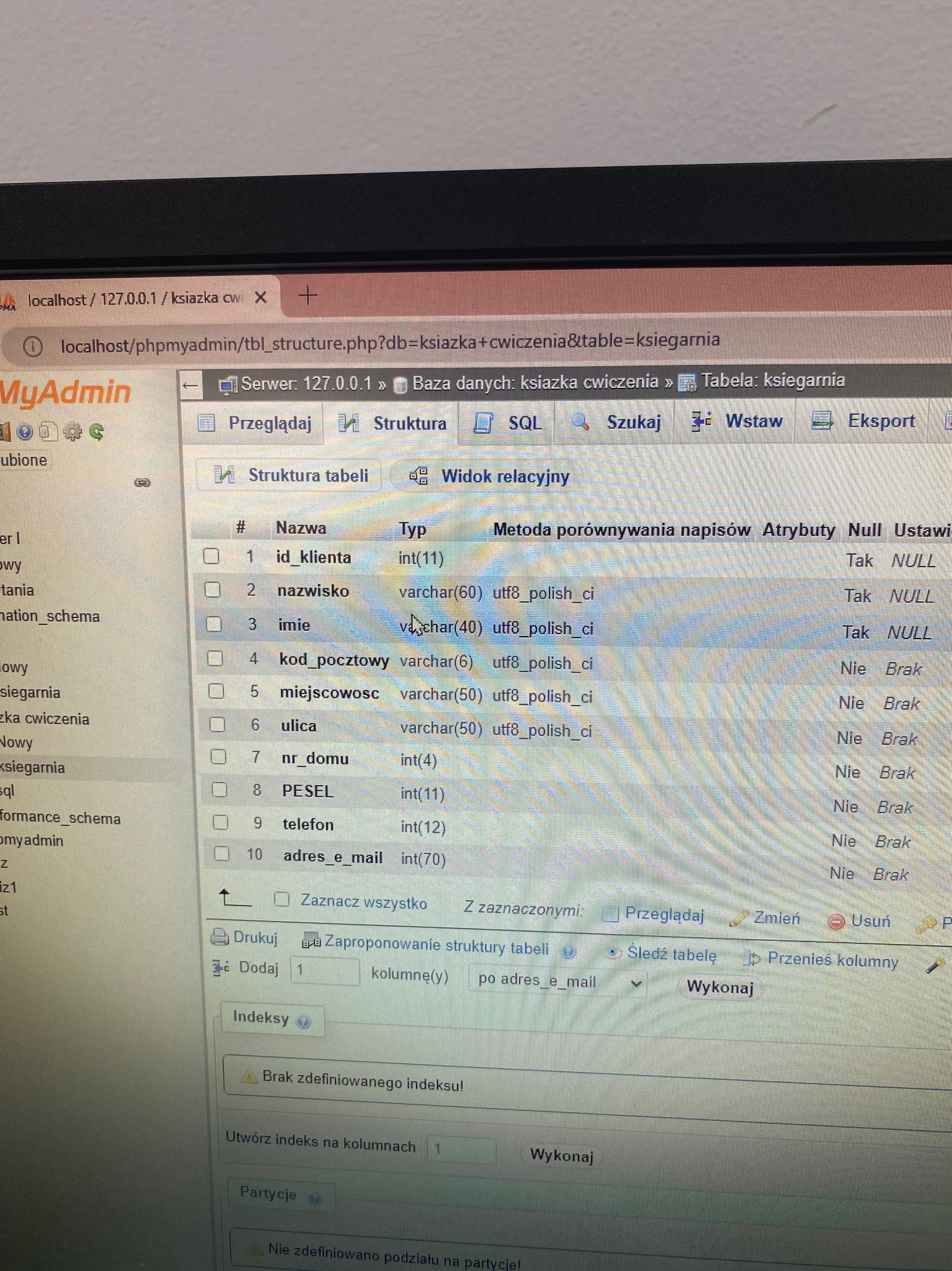 Widok struktury tabeli 'ksiegarnia' w phpMyAdmin, prezentujący pola takie jak 'id_klienta', 'nazwisko', 'imie', 'kod_pocztowy', 'miejscowosc', 'ulica', 'nr_domu', 'PESEL', 'telefon', 'adres_e_mail'...