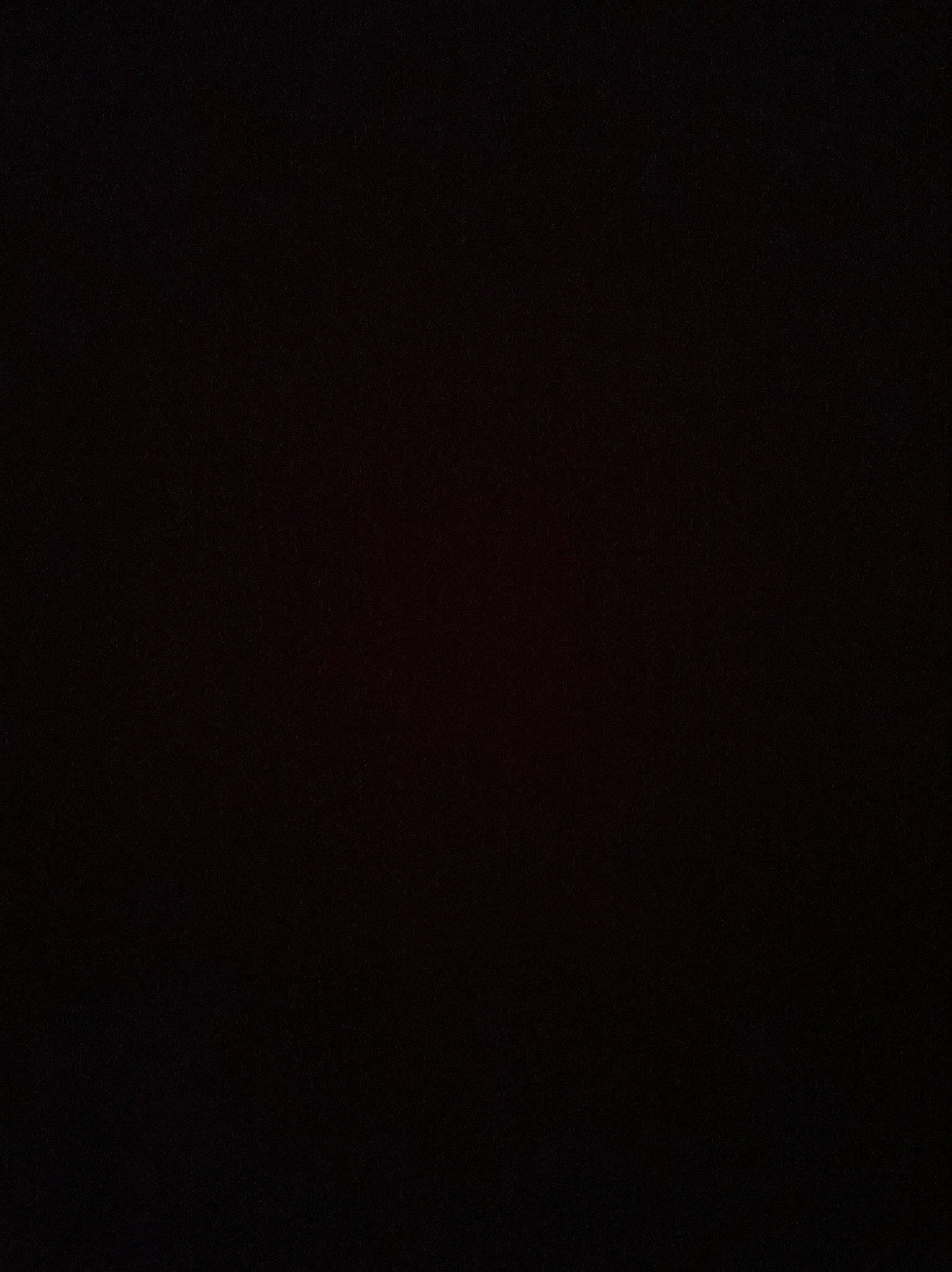 Ciemne zdjęcie, prawdopodobnie przedstawiające ekran smartfona z niedokończonym projektem strony internetowej dla pizzerii w edytorze Canva, choć detale są niewidoczne.