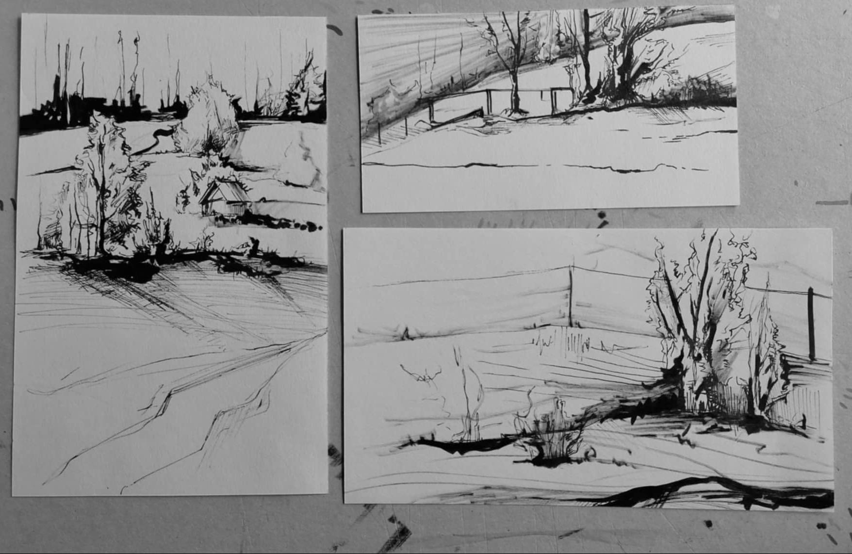 Trzy szkice krajobrazu wykonane czarnym tuszem na białym papierze, przedstawiające wiejskie widoki z drzewami i budynkami, z różnym stopniem szczegółowości i perspektywy.