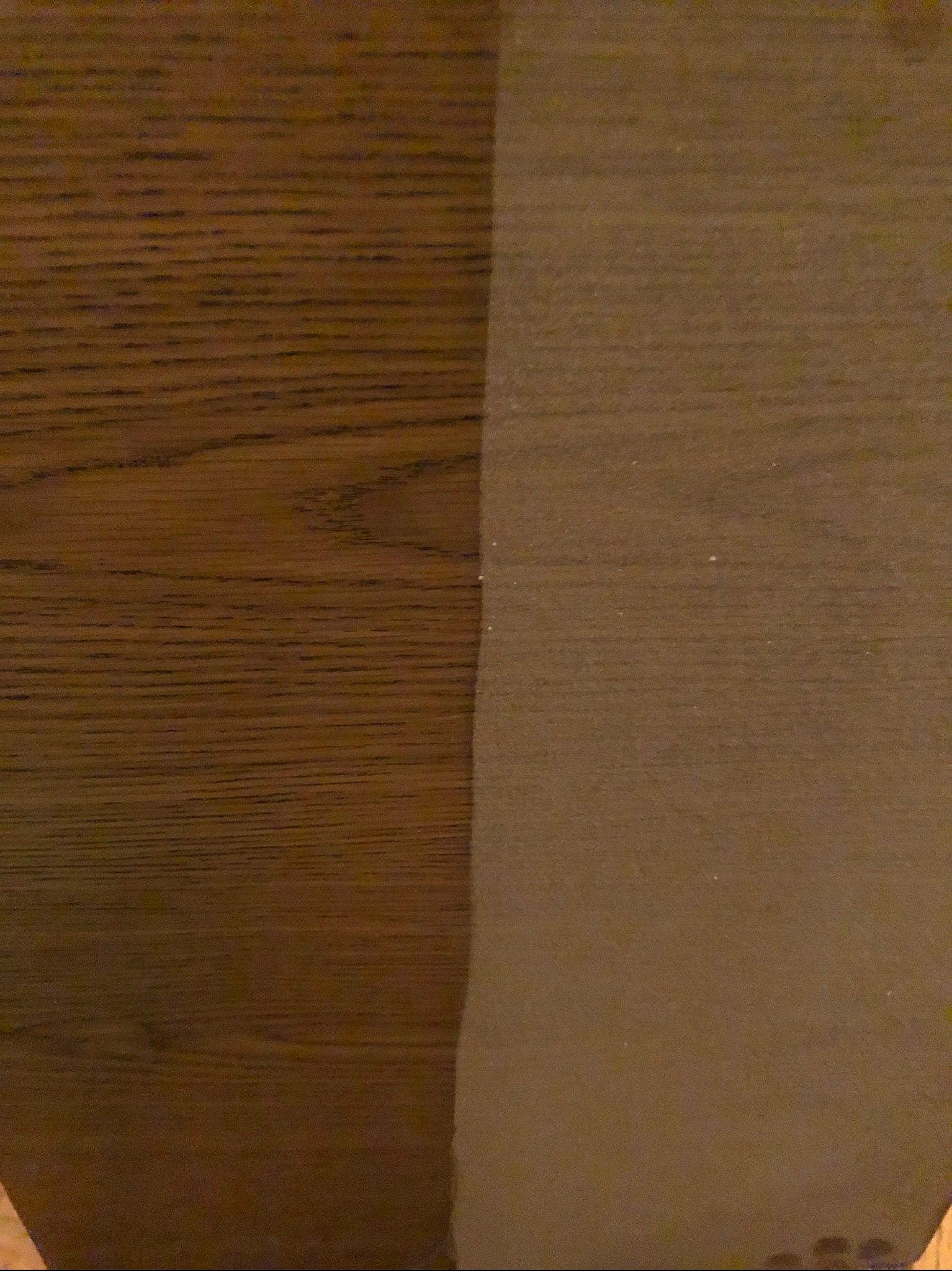 Fragment drewnianej powierzchni, po lewej stronie widoczny brudny, matowy obszar, po prawej czysty, błyszczący.