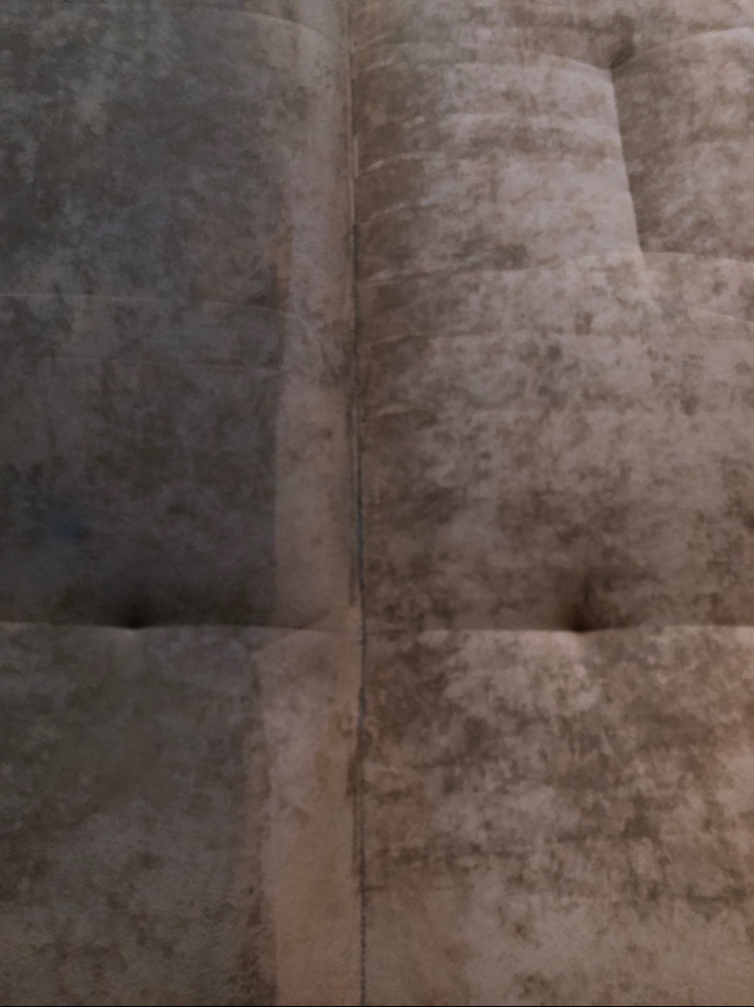 Fragment brudnego, beżowo-szarego dywanu z widocznymi plamami i przeszyciami, ukazujący różnicę w czystości po jego częściowym wypraniu.