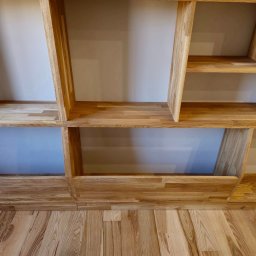 Meble w Twojej okolicy - Półki wykonane z jasnego drewna dębowego, zamontowane na ścianie, z widoczną strukturą drewna na podłodze